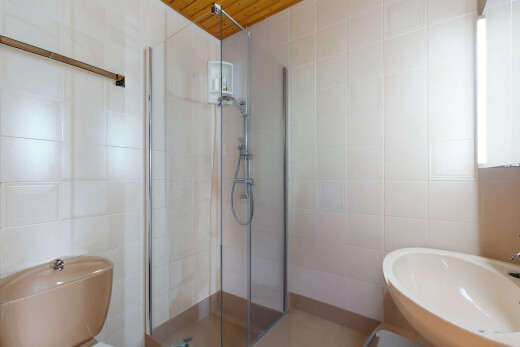 salle de bains avec douche, évier, salle de bain complète, et mur en carrelage