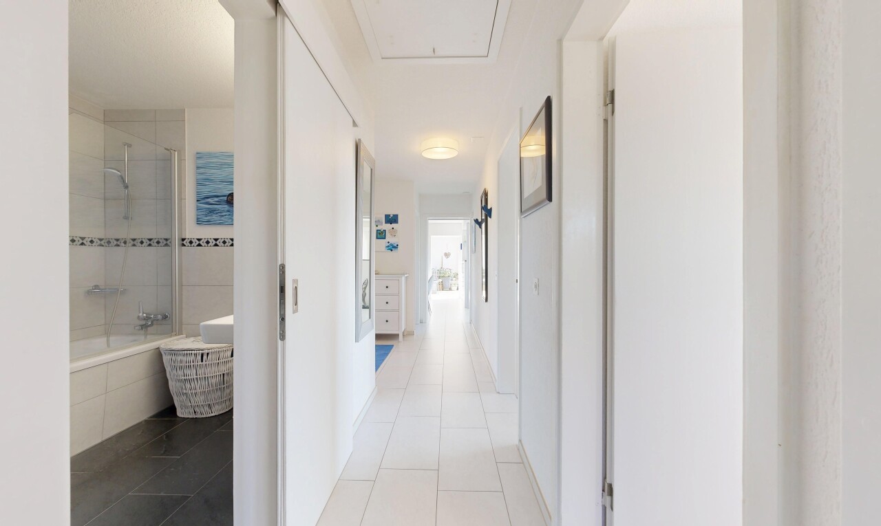 couloir avec inside property, cloison sèche, drywall, sol en carrelage, et tile floor