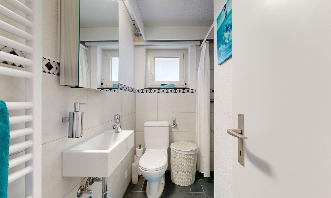 salle de bains avec chauffe-serviettes, miroir, radiateur, toilette, et inside property
