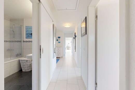 couloir avec inside property, cloison sèche, drywall, sol en carrelage, et tile floor