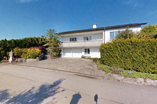 außenansicht mit day time, auffahrt, eingebaute garage, property visible, und stuckverkleidung