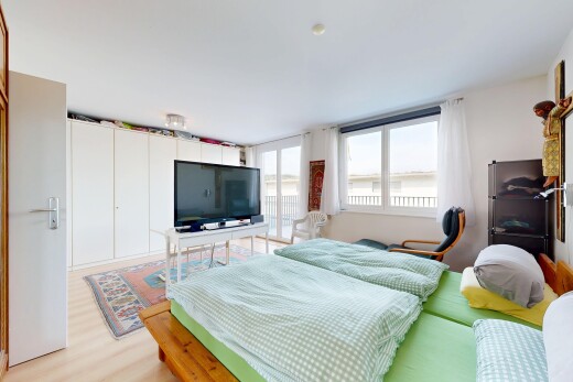 chambre avec télévision, inside property, natural light, lumière naturelle, et wood finish floor