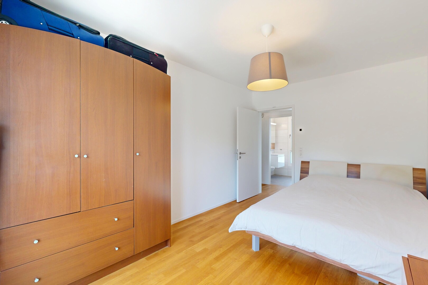 chambre avec éclairage suspendu, sol en finition bois, wood finish floor, cloison sèche, et drywall