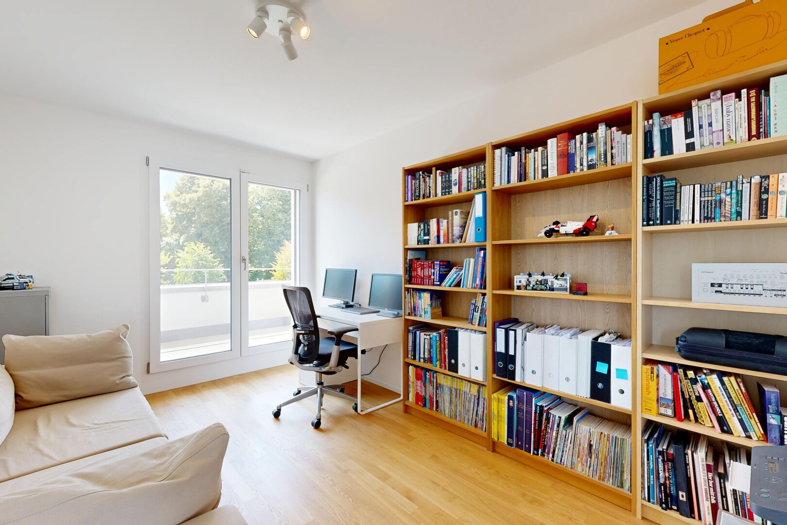 bureau avec sol en finition bois, wood finish floor, cloison sèche, drywall, et télévision