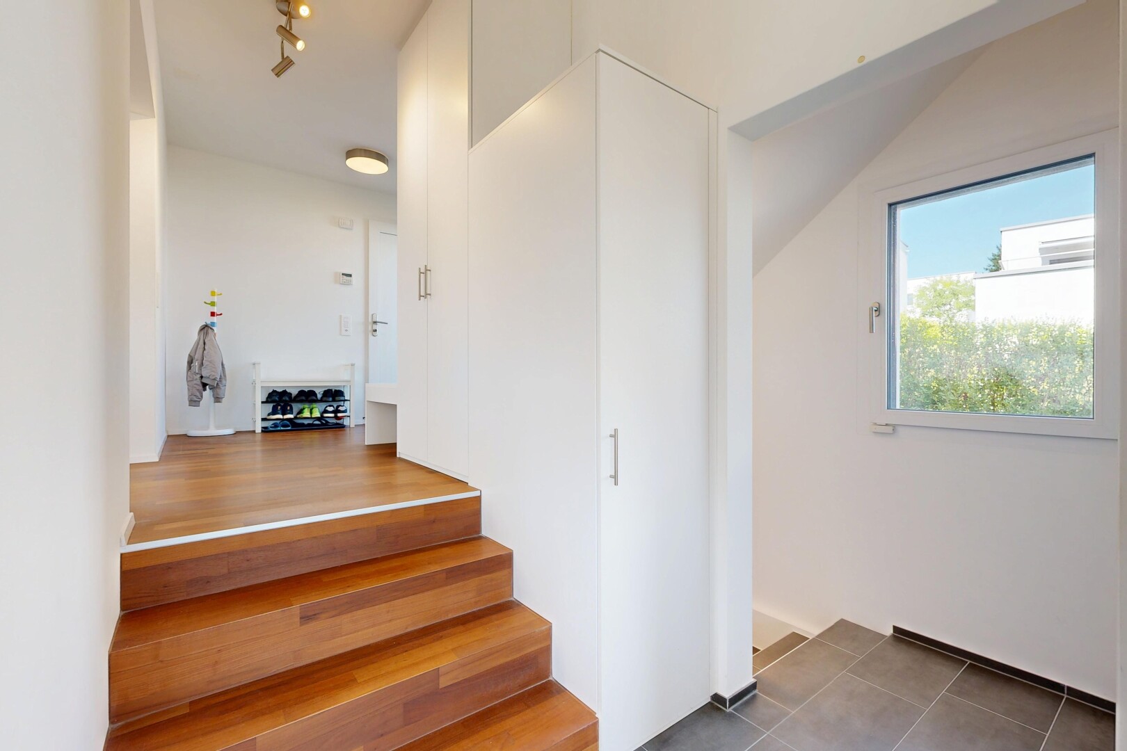 escaliers avec lumière naturelle, cloison sèche, drywall, inside property, et sol en carrelage