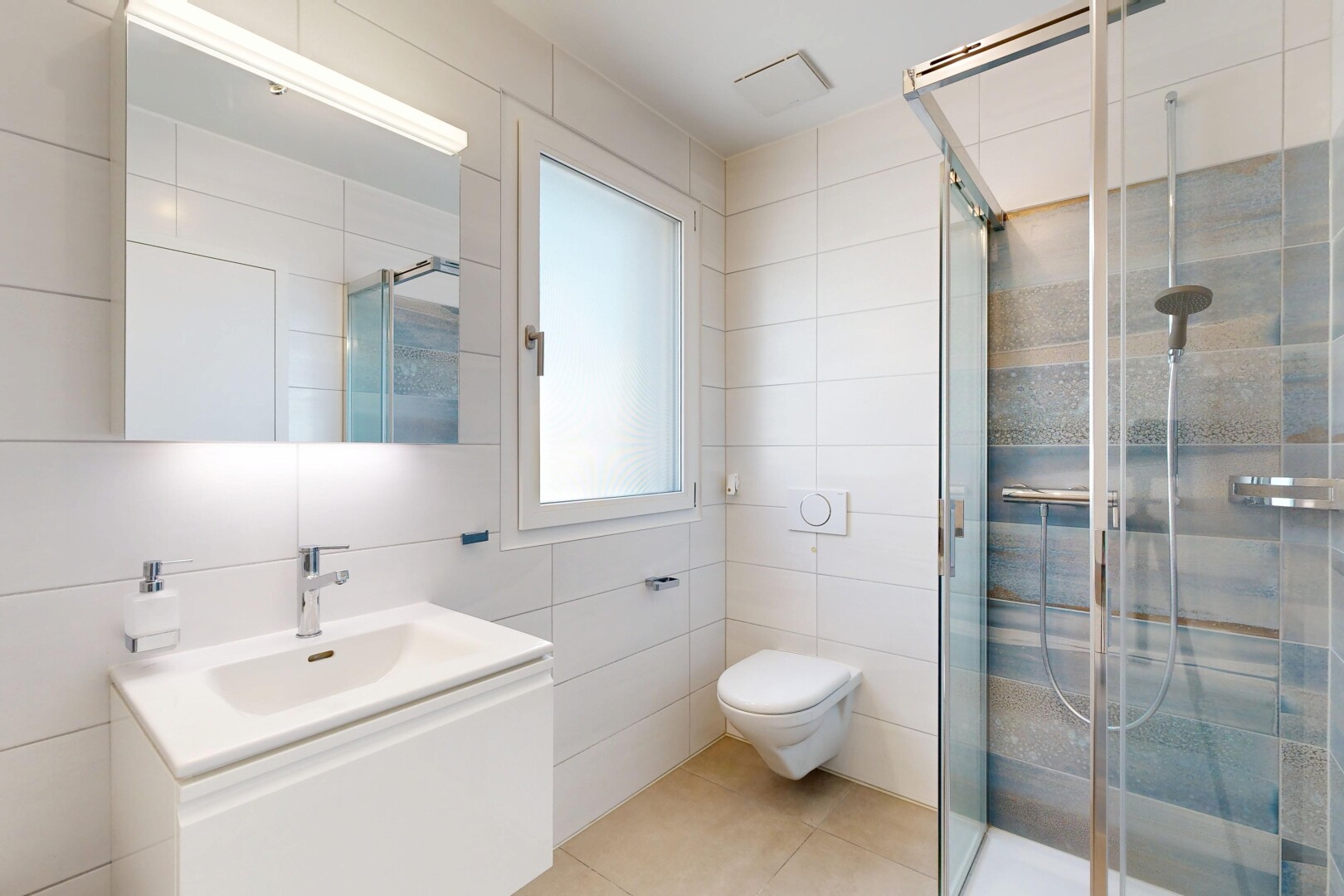 salle de bains avec tile wall, mur en carrelage, lavabo (ou coiffeuse selon le contexte), miroir, et douche