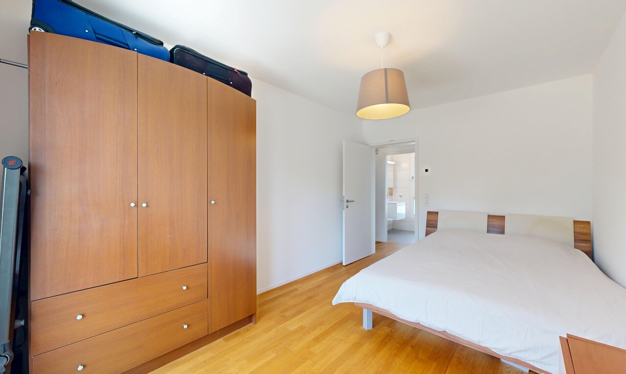 chambre avec éclairage suspendu, sol en finition bois, wood finish floor, cloison sèche, et drywall