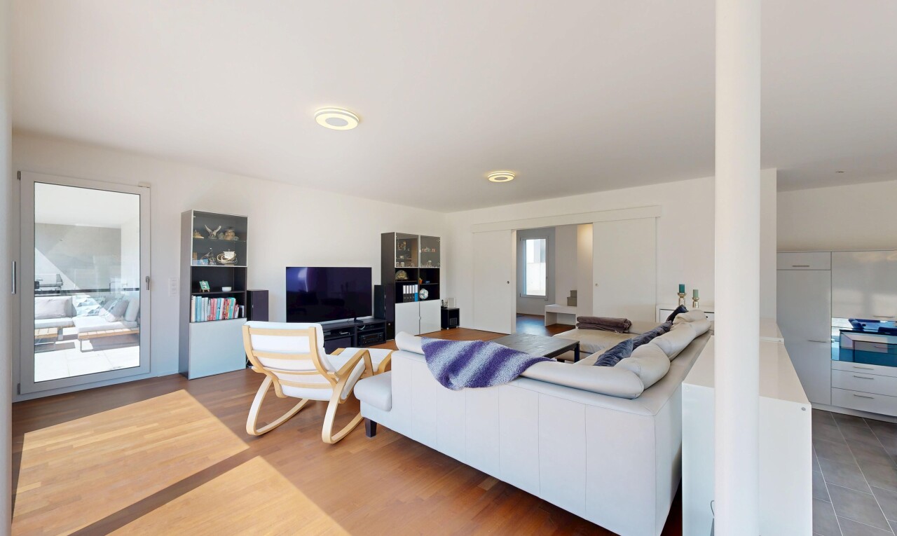 salon avec télévision, cloison sèche, drywall, sol en finition bois, et wood finish floor