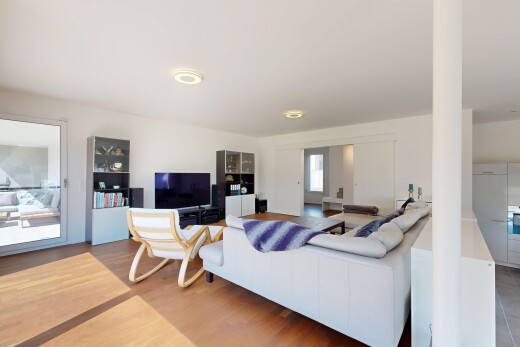 salon avec télévision, cloison sèche, drywall, sol en finition bois, et wood finish floor