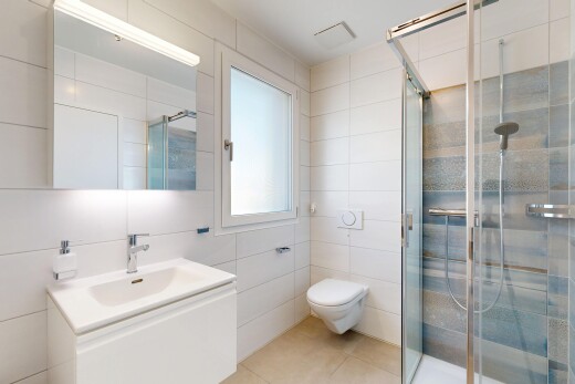 salle de bains avec tile wall, mur en carrelage, lavabo (ou coiffeuse selon le contexte), miroir, et douche