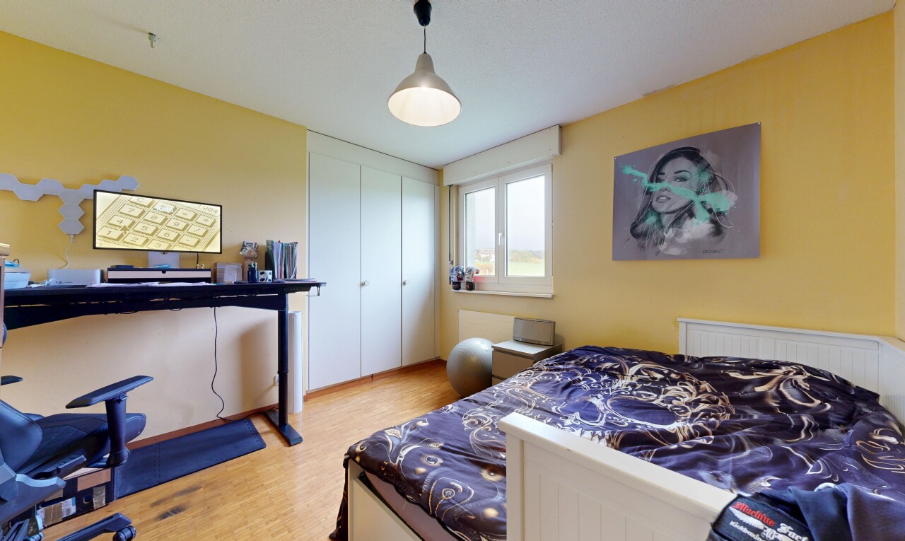 chambre avec cloison sèche, drywall, sol en finition bois, wood finish floor, et lumière naturelle