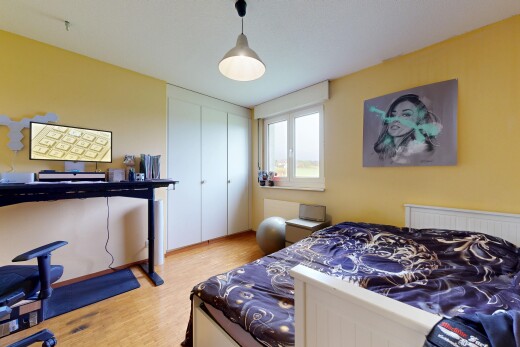 chambre avec cloison sèche, drywall, sol en finition bois, wood finish floor, et lumière naturelle