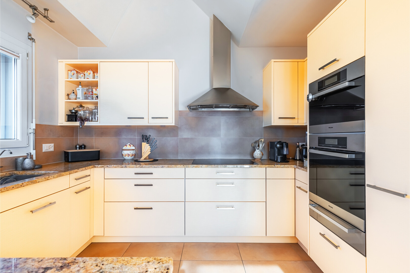 cuisine avec hotte, light floor, backsplash, dosseret, et four double