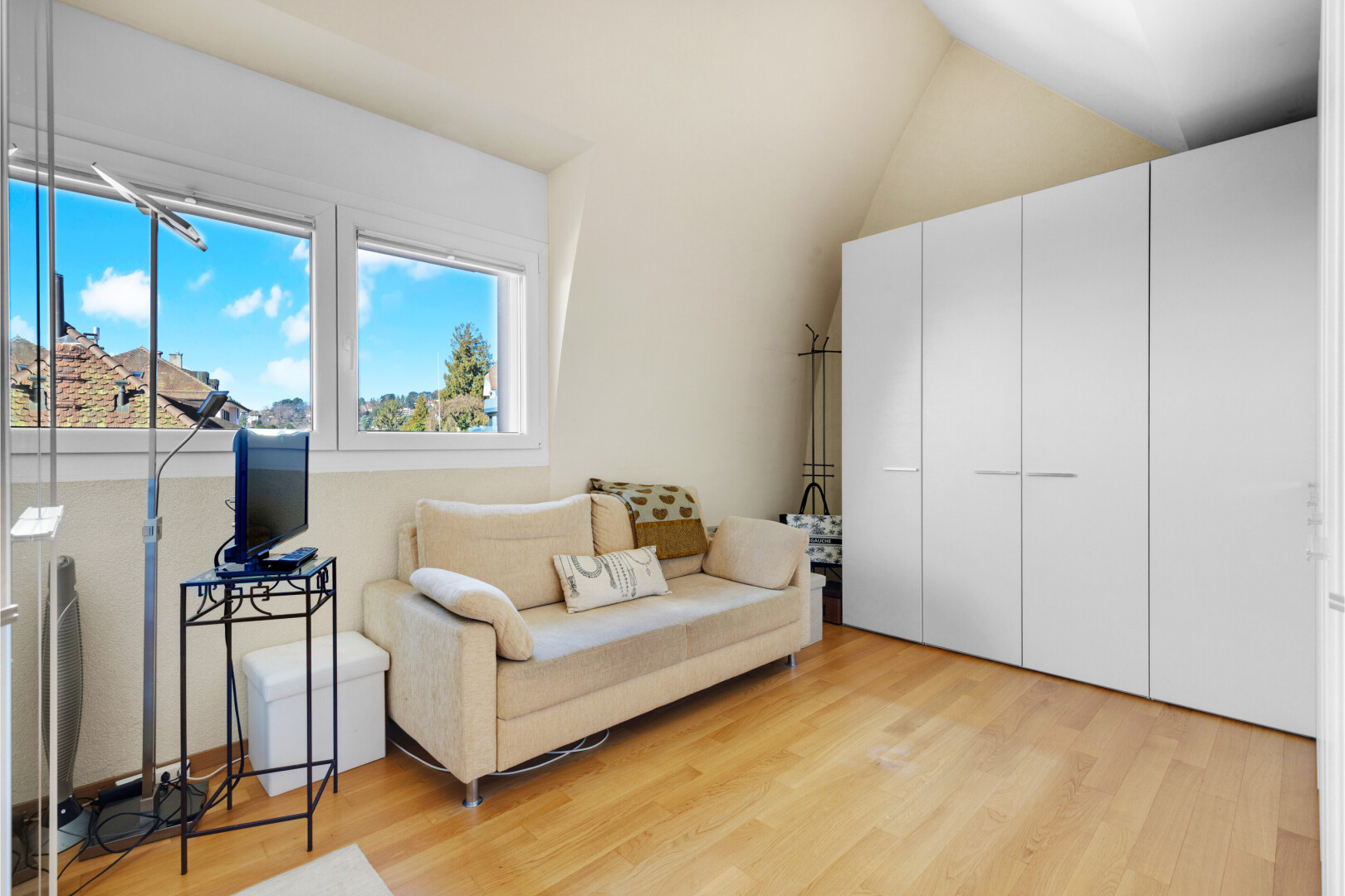 salon avec inside property, sol en finition bois, wood finish floor, télévision, et light floor