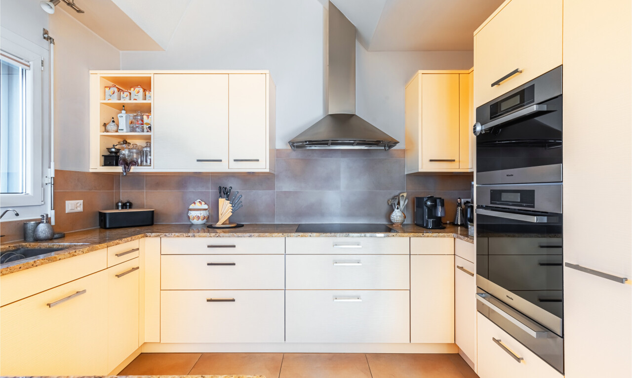 cuisine avec hotte, light floor, backsplash, dosseret, et four double