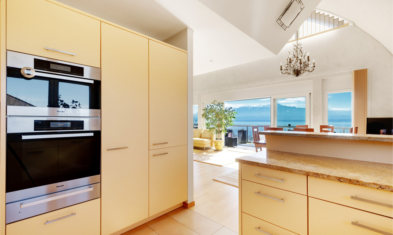 cuisine avec armoires crème, cream cabinets, two heights countertops, four double, et light floor