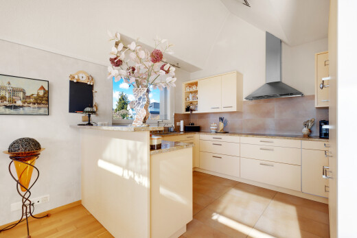 cuisine avec two heights countertops, hotte, cloison sèche, drywall, et péninsule de cuisine