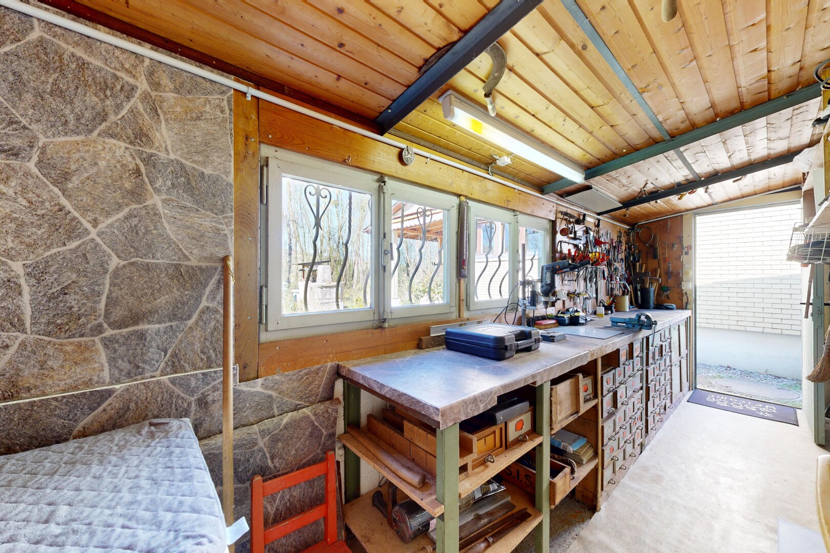 salle à manger avec inside property, atelier, mur en pierre, stone wall, et plafond en bois