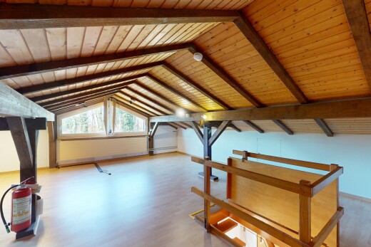 leerer raum mit holzfußboden, natürliches licht, dachschräge, und balkendecke