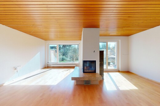 leerer raum mit gipskartonwand, natürliches licht, kamin, und holzfußboden