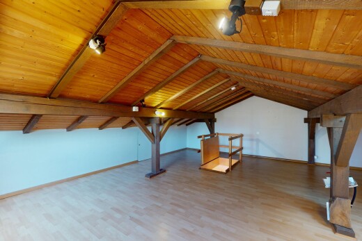 leerer raum mit dachschräge, gipskartonwand, holzfußboden, und holzdecke