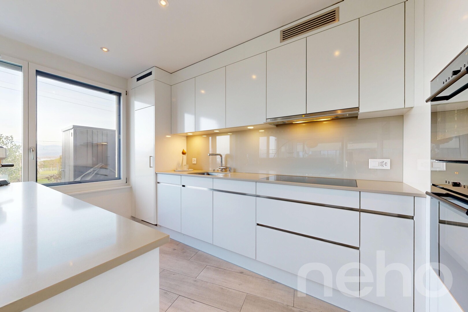 cuisine avec armoires blanches, white cabinets, light floor, armoires à panneau plat, et flat panel cabinets