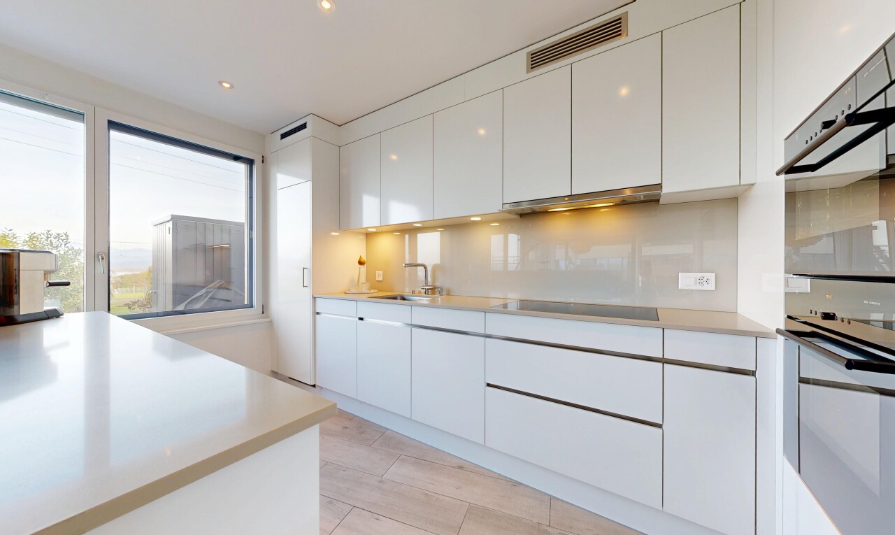 cuisine avec armoires blanches, white cabinets, light floor, armoires à panneau plat, et flat panel cabinets