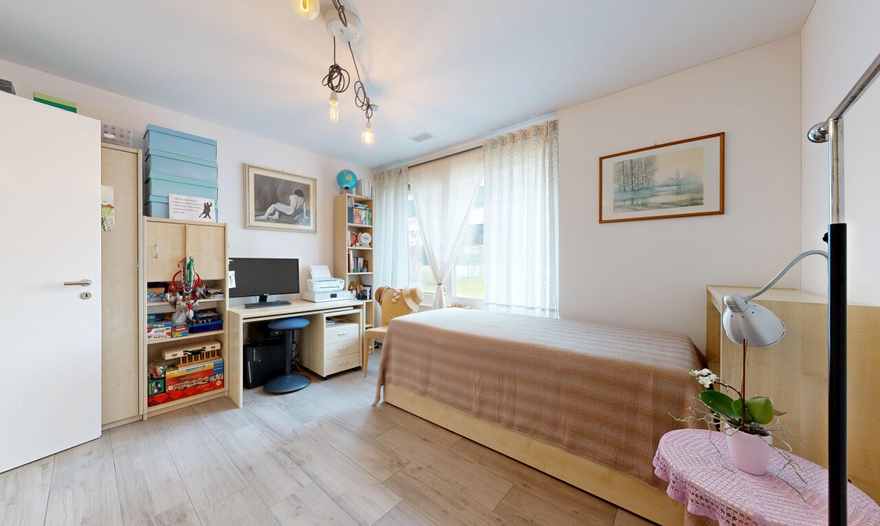 chambre avec espace bureau, natural light, lumière naturelle, wood finish floor, et sol en finition bois