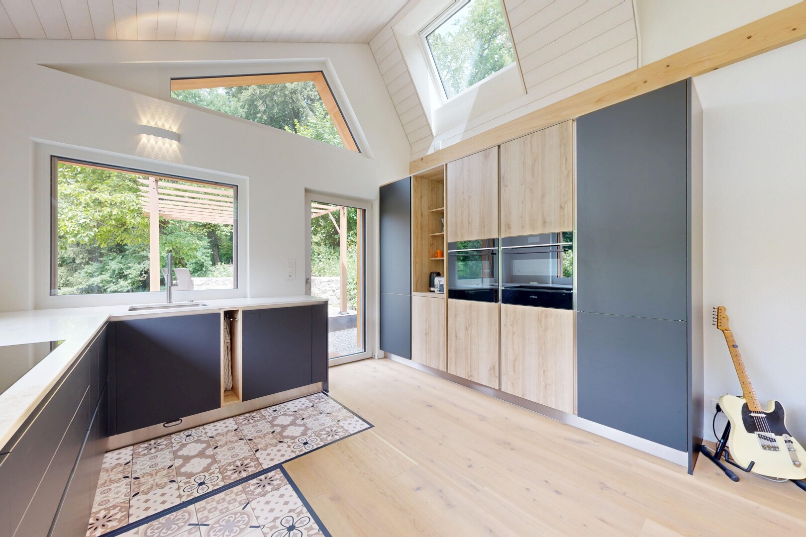 cuisine avec armoires marron clair, light brown cabinets, inside property, armoires à panneau plat, et flat panel cabinets