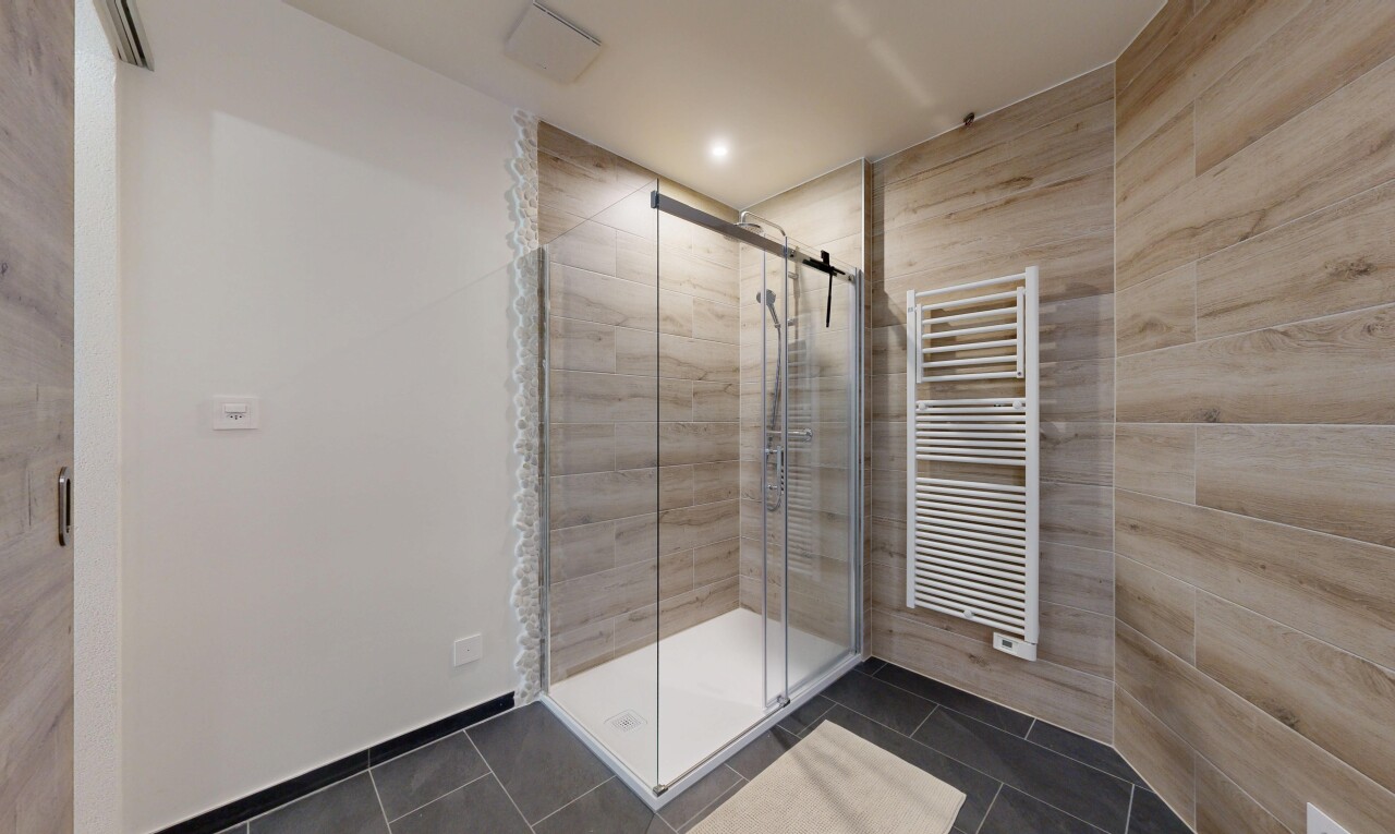 salle de bains avec dark floor, douche, chauffe-serviettes, radiateur, et salle de bain complète
