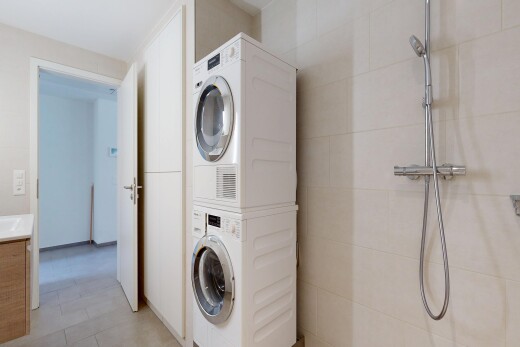 buanderie avec buanderie, lave-linge et sèche-linge superposés, light floor, et inside property