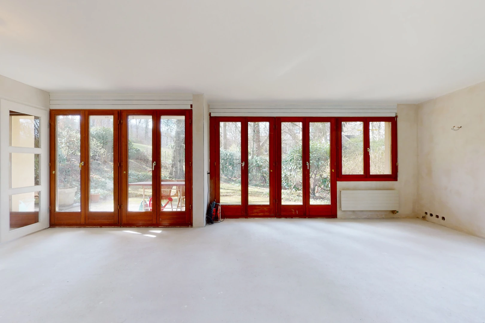 chambre vide avec moquette, lumière naturelle, et radiateur