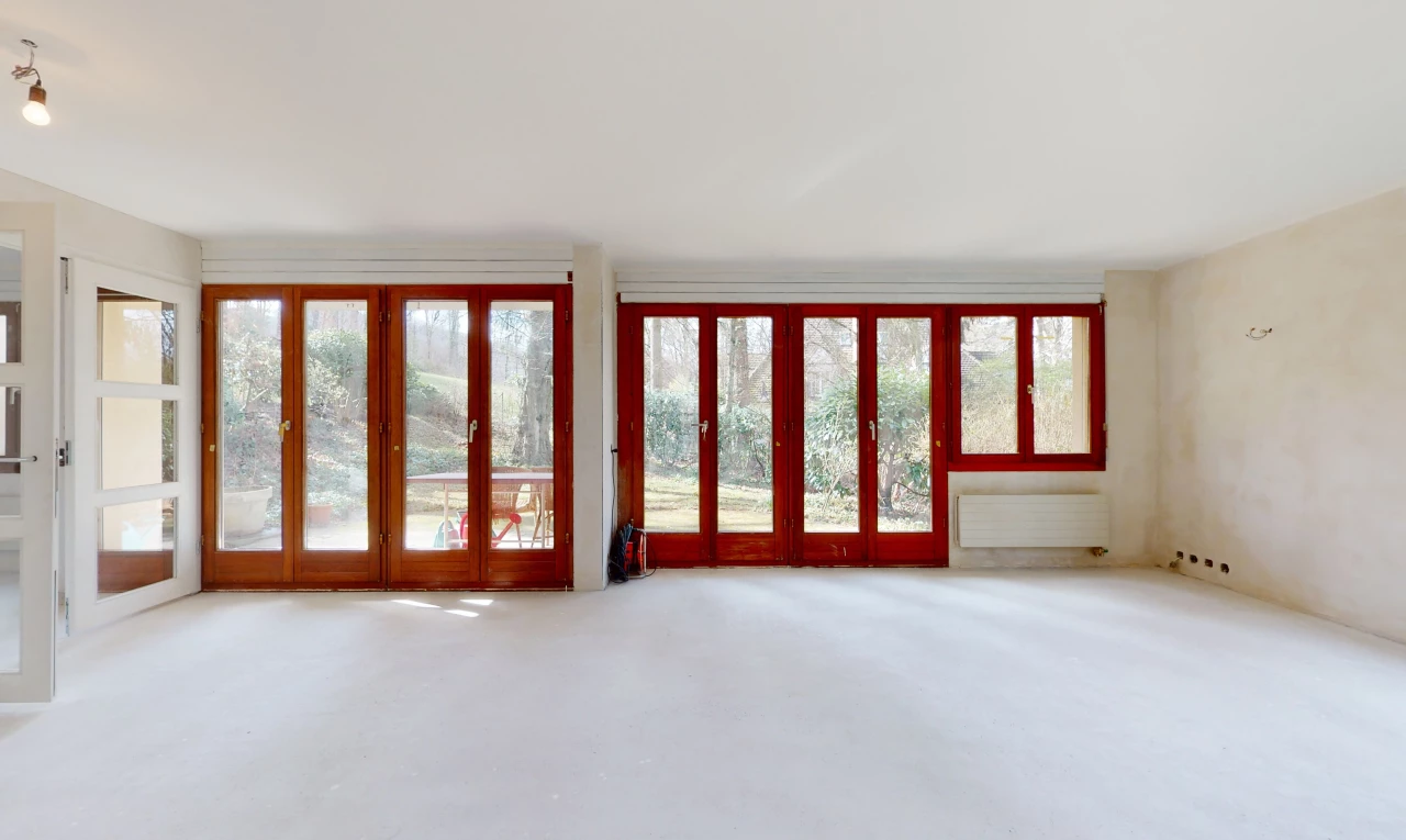 chambre vide avec moquette, lumière naturelle, et radiateur