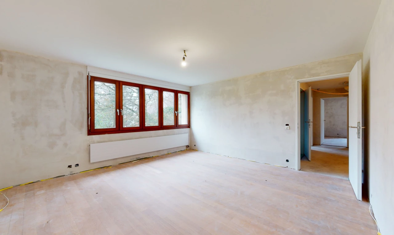 chambre vide avec lumière naturelle et parquet
