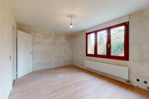 chambre vide avec lumière naturelle, parquet, et radiateur