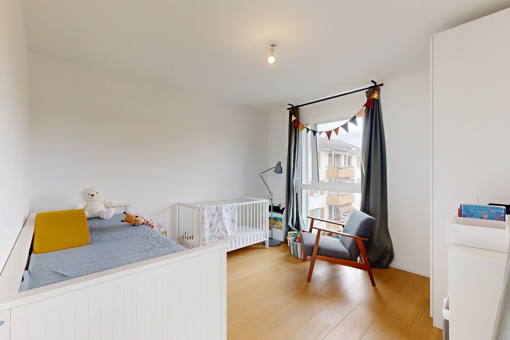 chambre avec drywall, cloison sèche, wood finish floor, sol en finition bois, et lumière naturelle