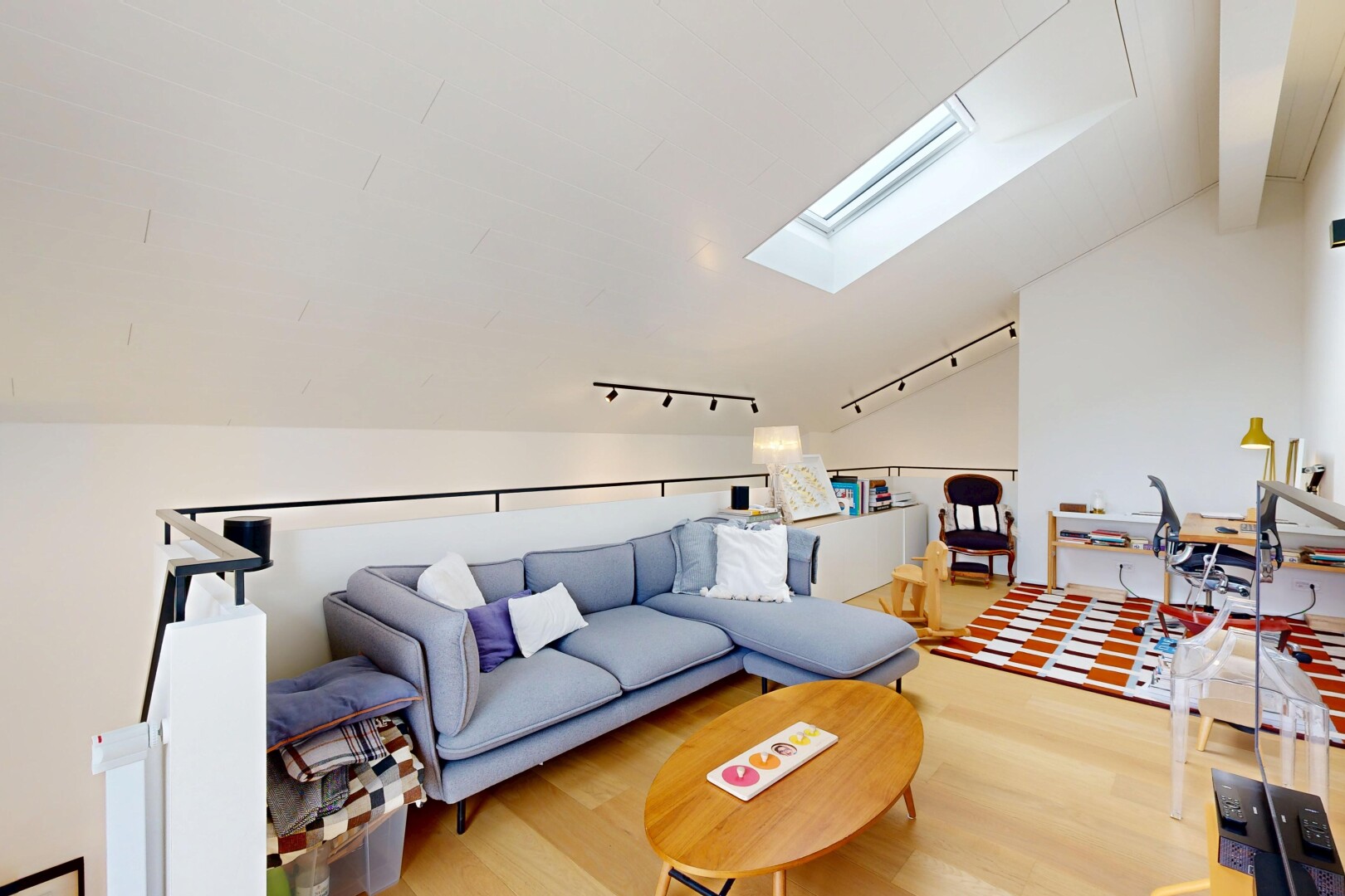 salon avec vaulted ceiling, plafond voûté, éclairage sur rail, puits de lumière, et télévision