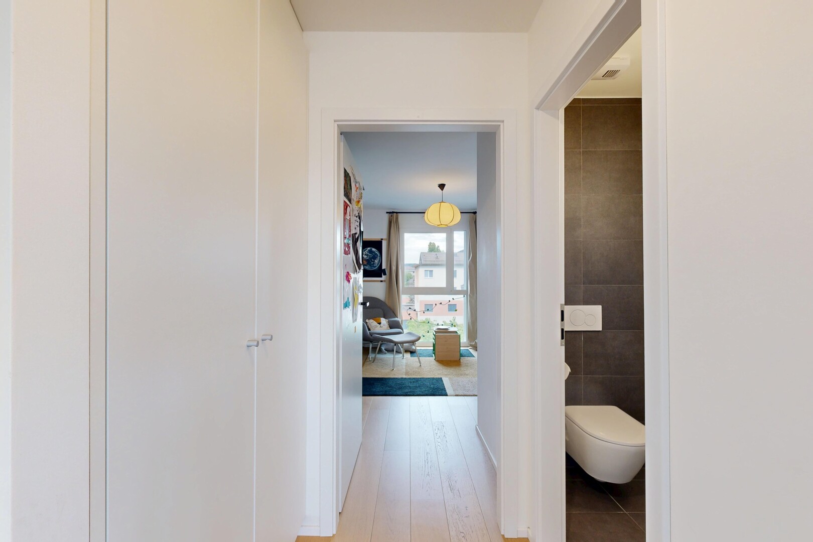 couloir avec éclairage suspendu, light floor, inside property, mur en carrelage, et tile wall