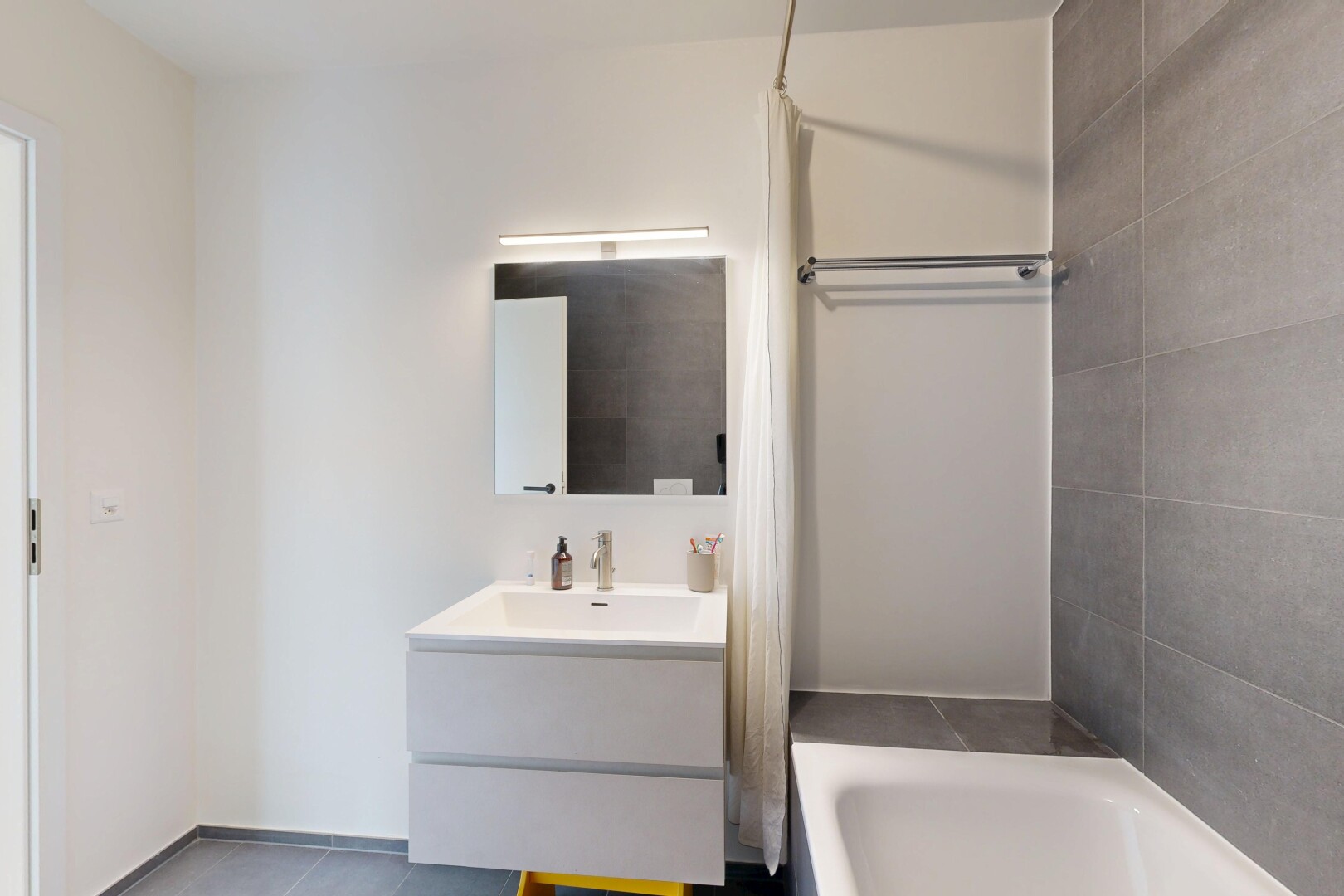 salle de bains avec salle de bain complète, lavabo (ou coiffeuse selon le contexte), miroir, drywall, et cloison sèche