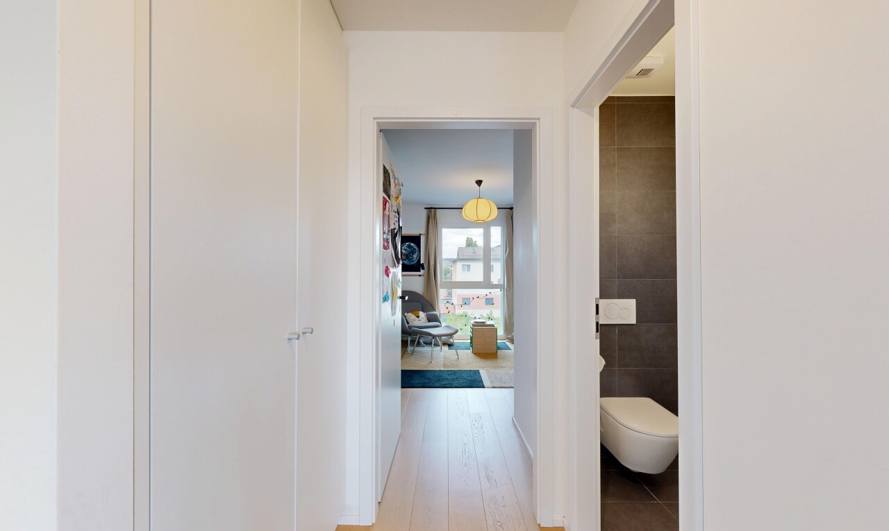 couloir avec éclairage suspendu, light floor, inside property, mur en carrelage, et tile wall