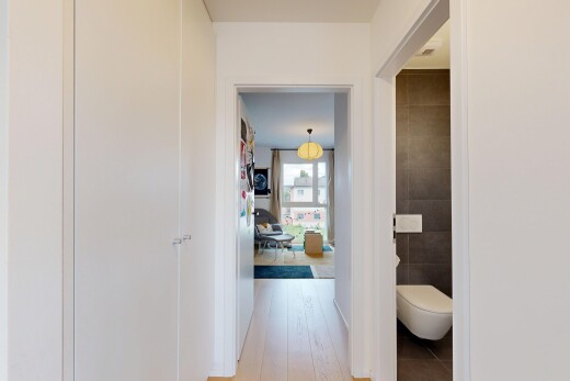 couloir avec éclairage suspendu, light floor, inside property, mur en carrelage, et tile wall