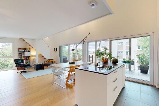 cuisine avec dark countertops, plans de travail, white cabinets, armoires blanches, et opens to living area
