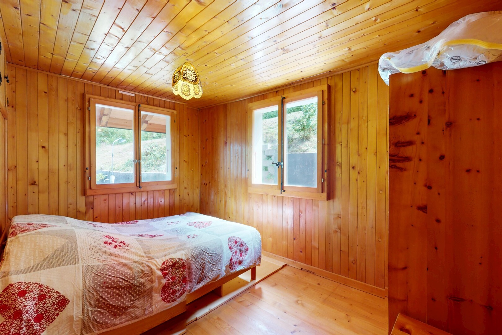 room / bedroom with light wood-style flooring, multiple windows, wooden walls, and wooden ceiling