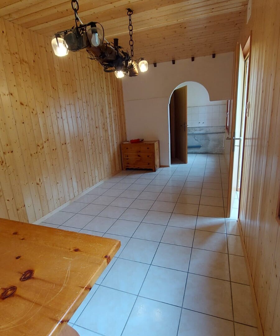 corridor with tile patterned floors, arched walkways, and wooden walls