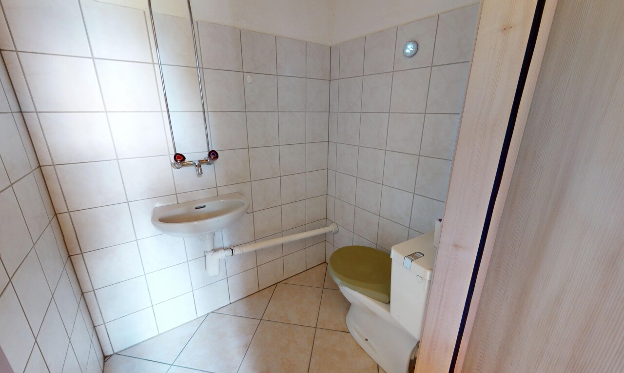 half bath featuring tile patterned flooring and tile walls