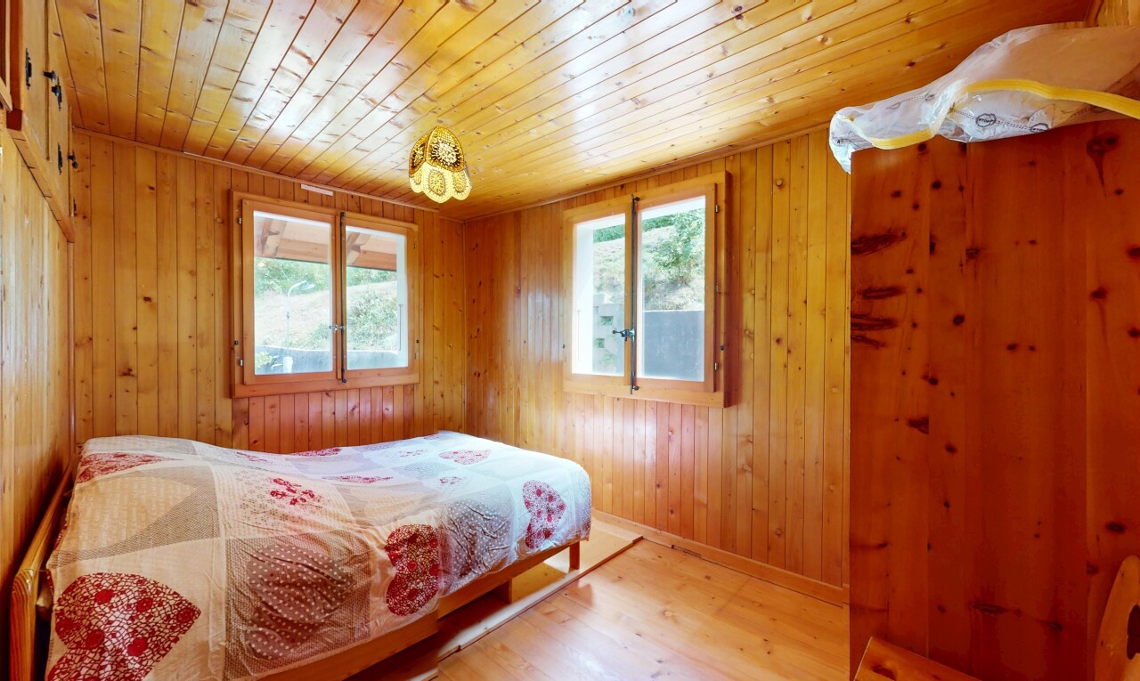 room / bedroom with light wood-style flooring, multiple windows, wooden walls, and wooden ceiling
