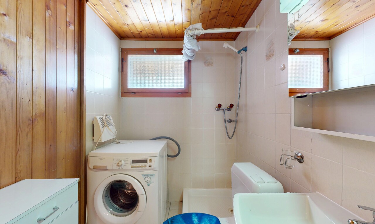 full bath with a tile shower, washer / clothes dryer, tile walls, wooden ceiling, and plenty of natural light
