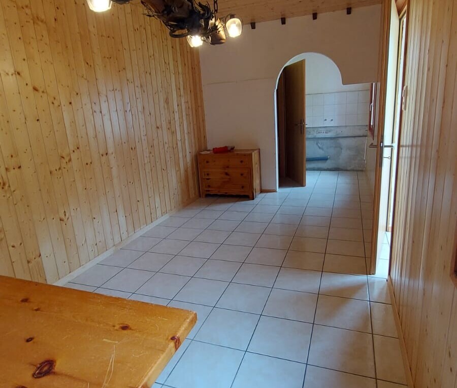 corridor with tile patterned floors, arched walkways, and wooden walls