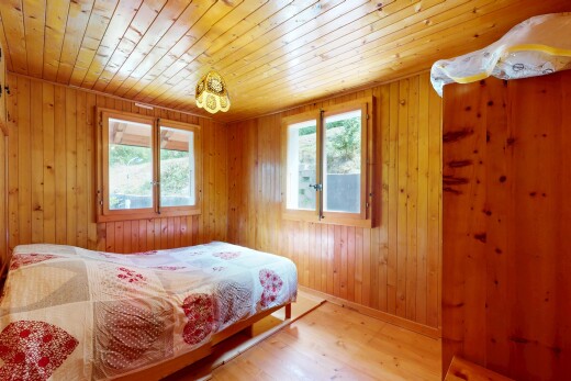 room / bedroom with light wood-style flooring, multiple windows, wooden walls, and wooden ceiling