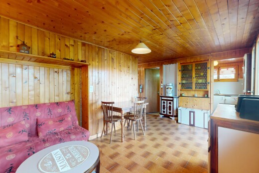 living room featuring wooden walls, tile patterned floors, and wooden ceiling